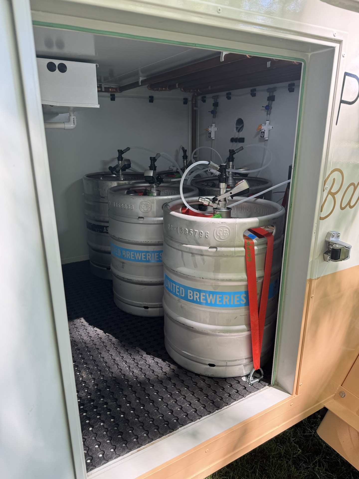 The Teardrop Bar's built-in coolroom door open, showing 50L kegs connected and chilled inside