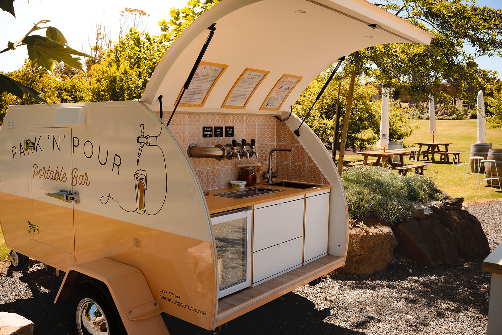 Park 'n' Pour teardrop bar parked at a winery with the hatch open and taps ready
